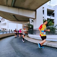 Mehrere Läufer joggen eine Parkhausauffahrt hoch.