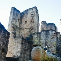 Burgruine aus Stein mit unterschiedlich hohen Türmen und Zinnen