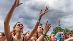 Menschen bei einem Musikkonzert, im Hintergrund der Dortmunder Fernsehturm Florian.