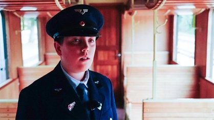 Leo steht in seiner Uniform in einem Wagon der Selfkantbahn.