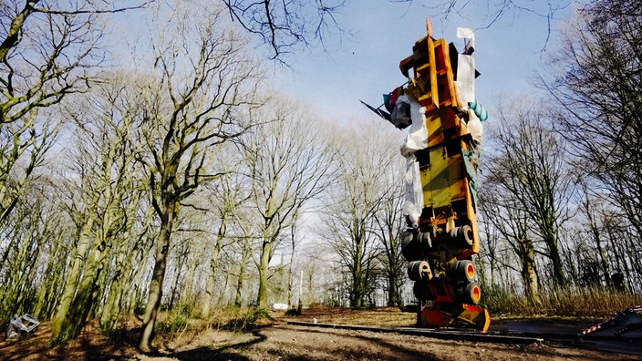 Ein Lkw-Anhänger steht als 14 Meter hohe Skulptur zwischen Bäumen im Skulpturenpark.