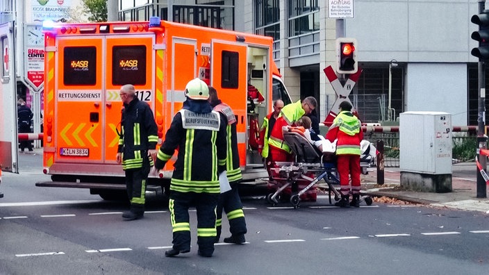 Vor einem Notarzt-Wagen versorgen zwei Rettungssanitäter eine Frau