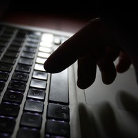 Finger tippen auf einem Laptop.