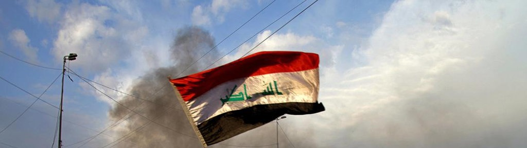 Irak, Baghdad: Ein Demonstrant schwenkt eine irakische Flagge. 