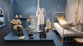 Das Beitragsbild des Dok5 "Herr Gammer gibt nicht auf" zeigt Einrichtungs und Ausstattungsgegenstände in der Ausstellung über die Fachklinik für Neurologie und Psychiatrie Altscherbitz.