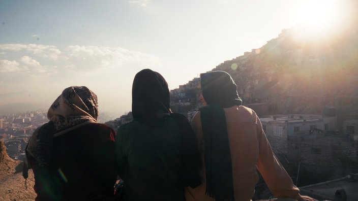 Das Beitragsbild des Dok5 "Verlorene Freiheit" zeigt die Hebammen Fatima und Zahra und deren Schwester Zainab auf einem Hausdach in Kabul.