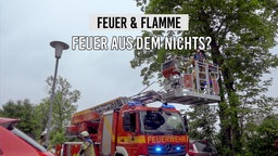Ein Feuerwehrauto steht vor einem Baum