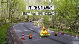 Feuerwehr steht auf der Straße mit einem Vorsicht-Zeichen