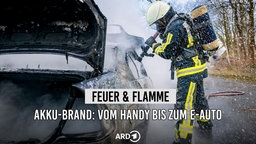 Ein Feuerwehrmann löscht ein Auto