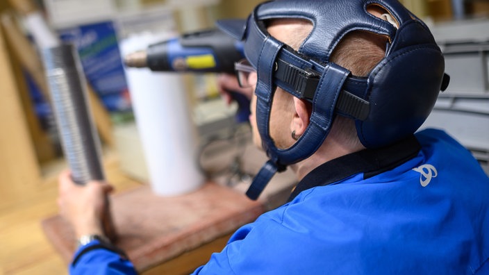 Das Beitragsbild des Dok5 "Förderbedarf – Arbeitsmöglichkeiten für Menschen mit Behinderung" zeigt einen Mann mit Bohrmaschine in einer Werkstatt für behinderte Menschen. 