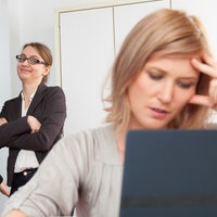 Kollegen lästern am Arbeitsplatz hinter dem Rücken einer Kollegin