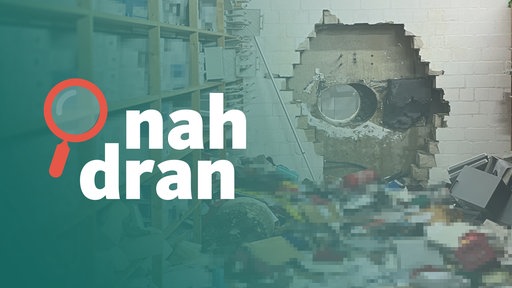 Das Bild zeigt den Tatort. Die Täter haben ein großes Loch in die Wand gebohrt. Viele Gegenstände liegen auf dem Boden. Im Vordergrund steht das Logo von "nah dran". 