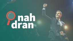 Der Wahlsieger Rob Jetten steht auf einer Bühne und hebt die rechte Faust. Links das Logo von nah dran.