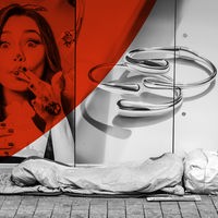 Das Beitragsbild des ARD Radiofeature "Schatten der City" zeigt einen Obdachlosen Menschen in der Innenstadt vor einem Schaufenster liegend.