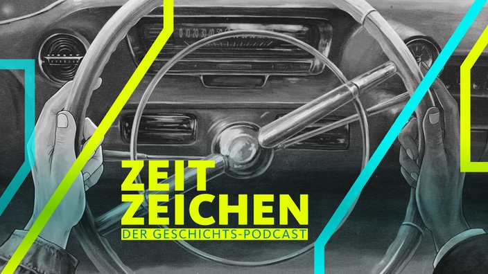 Eine weiße und eine Schwarze Hand am Lenkrad eines Autos