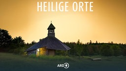 Die Quernst-Kapelle auf einer Lichtung im Nationalpark Kellerwald umgeben von Buchenwäldern im Abendlicht, vor gelbem Hintergrund; darüber der Titel der Reihe: "Heilige Orte".