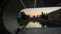 Blick durch den Bogen der Festina Lente Brücke auf Fluss Miljacka bei Dämmerung in Sarajevo.