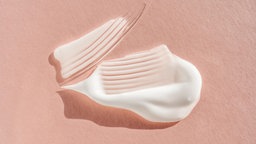 Nahaufnahme von einem Klecks Sonnencreme, die in zwei geschwungenen Streifen verteilt ist.