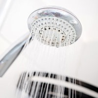 Ein Duschkopf hängt in einer Dusche in einem Badezimmer.