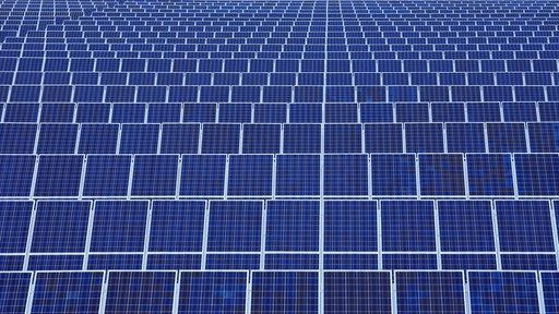 Das Bild zeigt einen Solarpark mit vielen Solaranlagen