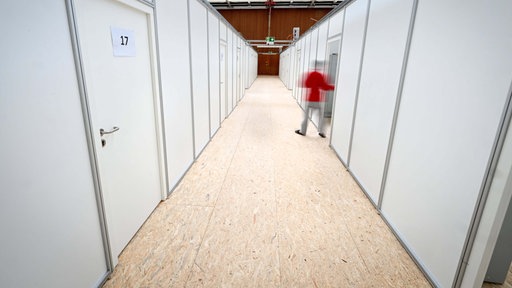 Ein Mann schließt eine Tür in der Notunterkunft in der Sporthalle der Berufsfachschule in Friedrichshafen am Bodensee.
