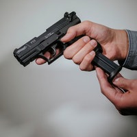 Ein Mann lädt eine Schreckschuss-Pistole "Walther P22" mit einem Magazin.