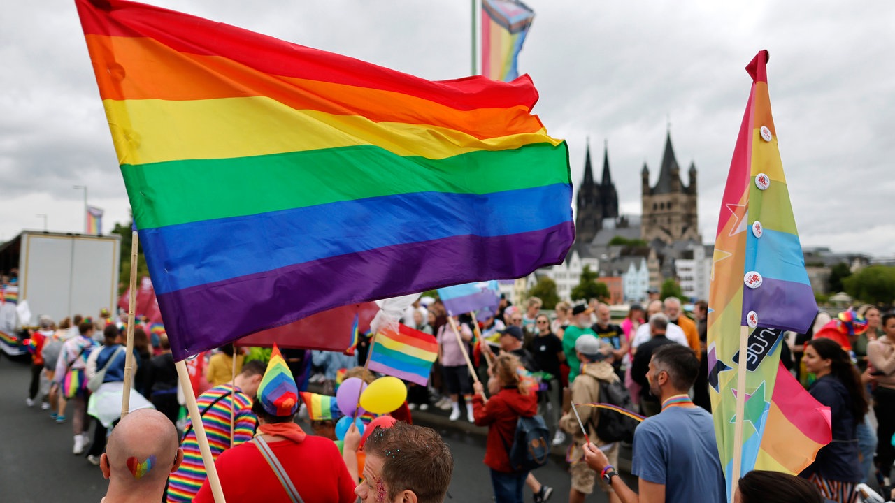 Teilnehmende des CSD mit Pride- und Regenbogenflaggen