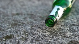 Eine leere Flasche liegt auf dem Boden