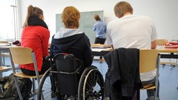 Eine körperbehinderte Schülerin nimmt am Unterricht in ihrer Abiturklasse am Humboldt-Gymnasium in Karlsruhe teil.