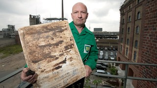 Ruppe Koselleck zeigt auf dem Balkon seines Ateliers in Münster eine seiner aktuellen Arbeiten aus der Reihe "Takeover BP", die er mit Ölklumpen von der im Golf von Mexiko gesunkenen Ölplattform Deepwater Horizon vor Ort geschaffen hat. 