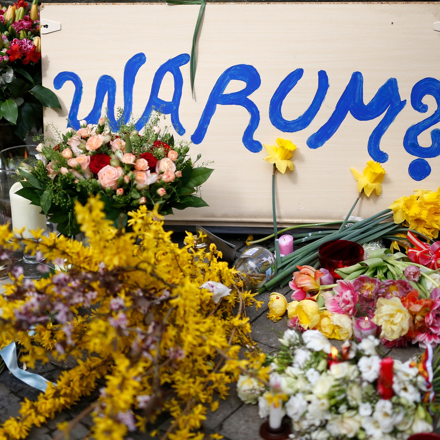 08.04.2018, Nordrhein-Westfalen, Münster: Ein Schild mit der Aufschrift "Warum?" liegt neben Blumen am Tatort der Amokfahrt von Münster.