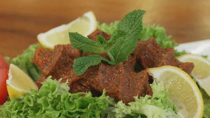 Giköpfte serviert mit Salat, Zitrone und Minze.