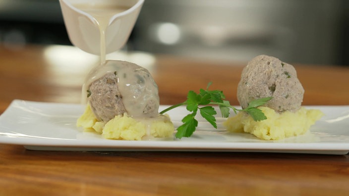 Königsberger Klopse serviert mit Kartoffelpüree.