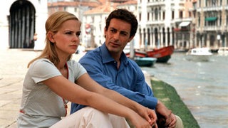 Mann und Frau sitzen in Venedig am Canale Grande