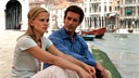 Mann und Frau sitzen in Venedig am Canale Grande