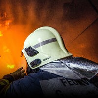 Feuerwehrmänner vor einer brennenden Wand