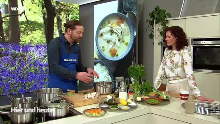 Koch Olaf Baumeister steht mit Moderatorin Anne Wilmes an der Küchenzeile vom Hier und Heute Studio