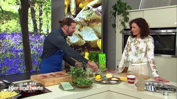 Koch Olaf Baumeister steht mit Moderatorin Anne Wilmes an der Küchenzeile vom Hier und Heute Studio