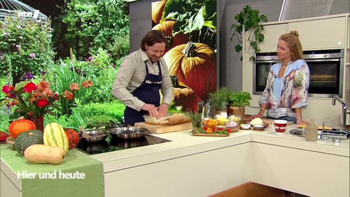 Olaf Baumeister knetet den Teig in eine Form und Miriam Lange schaut zu