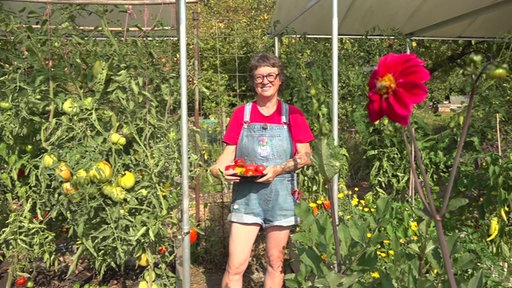Gartenexpertin Anja Klein mit einer gelben Tomate in der Hand