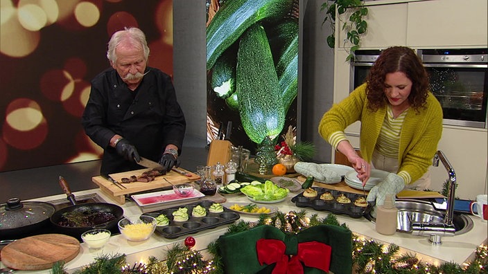 Henning Krautmacher und Anne Willmes bereiten Lammlachse im Amarenalack mit Zucchini-Röschen zu