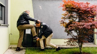 Hubert (Christian Tramitz, r.) und Girwidz (Michael Brandner, l.) bleibt nichts anderes übrig als im Team zu arbeiten. Sie versuchen ein Gebäude zu erklimmen.