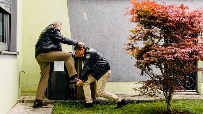 Hubert (Christian Tramitz, r.) und Girwidz (Michael Brandner, l.) bleibt nichts anderes übrig als im Team zu arbeiten. Sie versuchen ein Gebäude zu erklimmen.