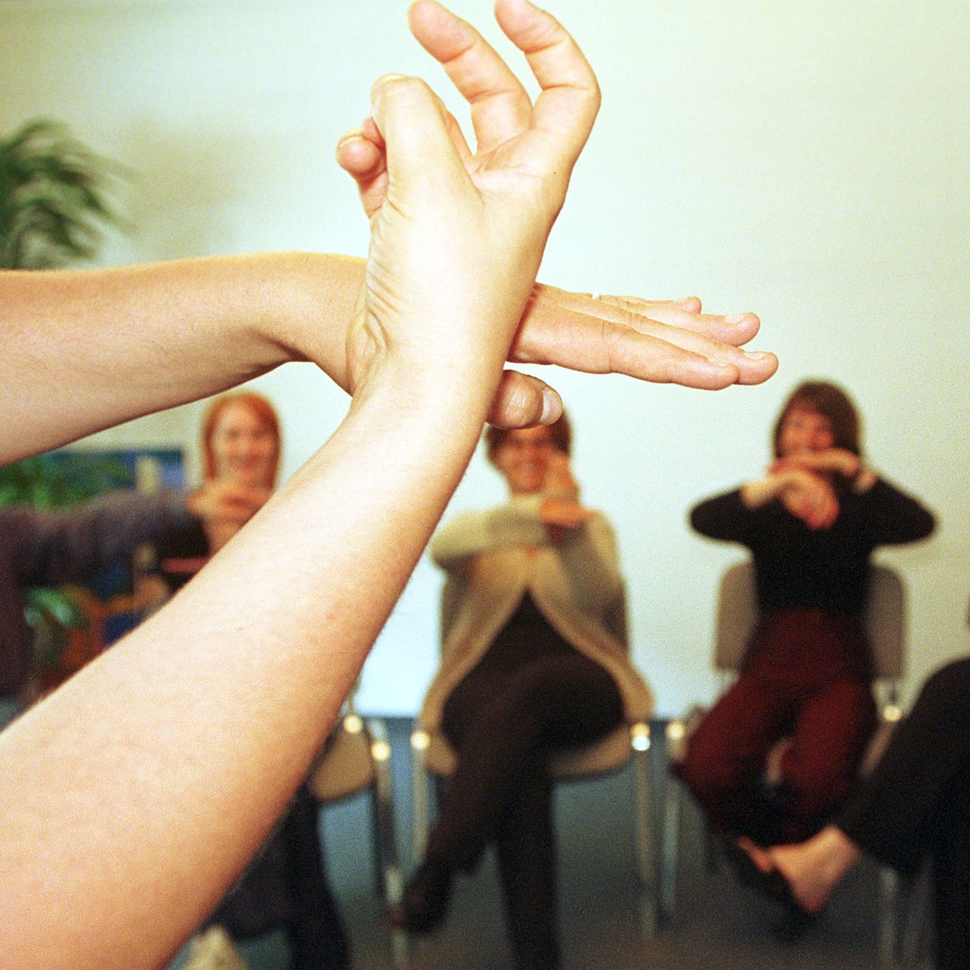 Menschen sitzen im Stuhlkreis und unterhalten sich mittels Gebärdensprache