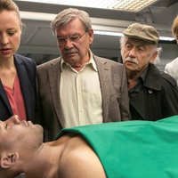 Dr. Rosalind Schmidt (Helene Grass, r.) teilt Vicky (Katja Danowski, l.), Günter (Wolfgang Winkler, 2.v.l.) und Edwin (Tilo Prückner, 2.v.r.) das Ergebnis der Obduktion mit. Connor Taylor (Roy Wesche, vorne) ist an einem Herzinfarkt gestorben.