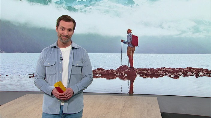 Daniel Aßmann und im Hintergrund ein Bild von einem Backpacker
