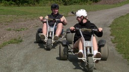 Das Bild zeigt Emily und Benny beim Mountain-Cart-Fahren. 
