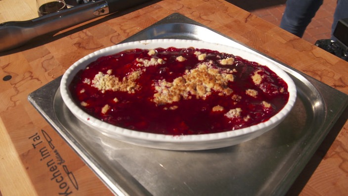 Das Bild zeigt Pfirsiche und Beerencrumble vom Grill in einer Auflaufform.