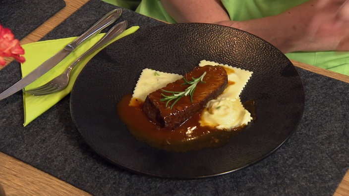 Der Schmorbraten und die Raviolo serviert mit Wurzelgemüse-Frischkäse Füllung.