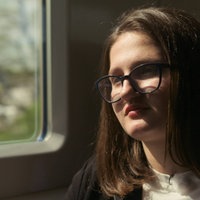 Erika im Zug. Sie schaut in die Ferne.